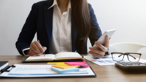 Midsection of businessman working at desk in office