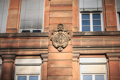 Low angle view of clock on window of building