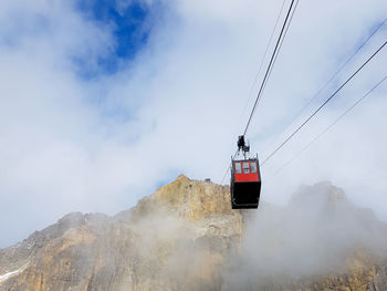 Low angle view of overhead cable car against sky