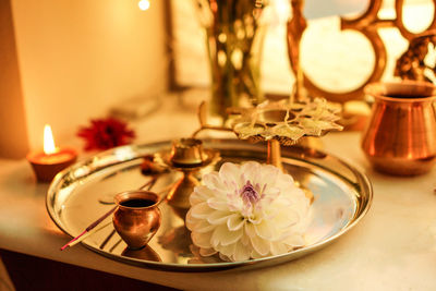 Close-up of traditional utensil and flower in plate