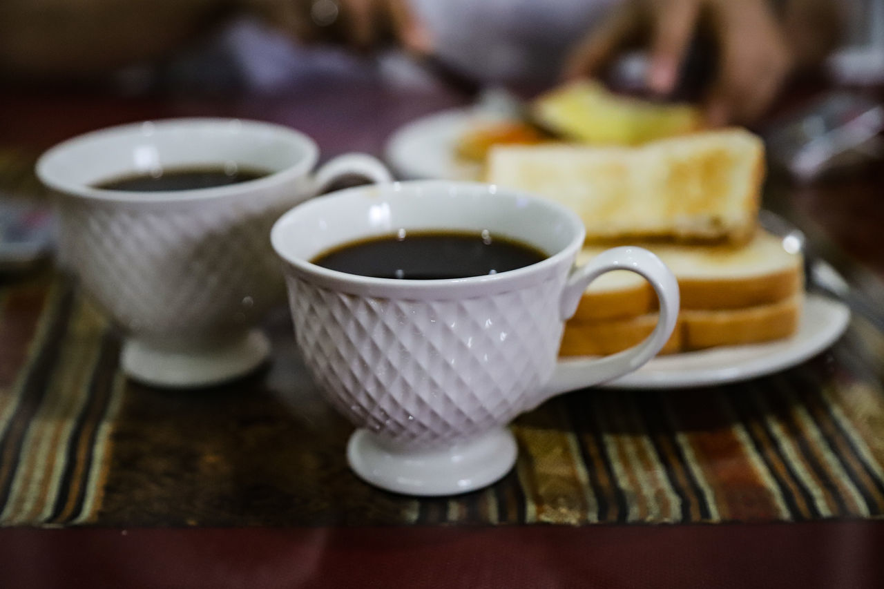 CLOSE-UP OF COFFEE CUP AND TABLE