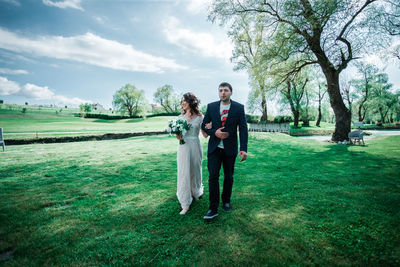 Full length of young couple standing in park