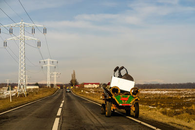 Vehicles on road against sky in city