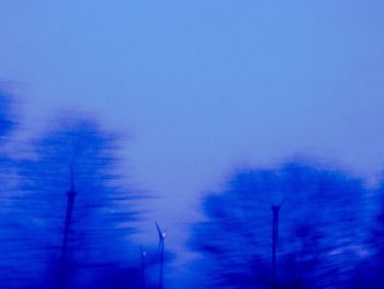 Low angle view of trees against cloudy sky