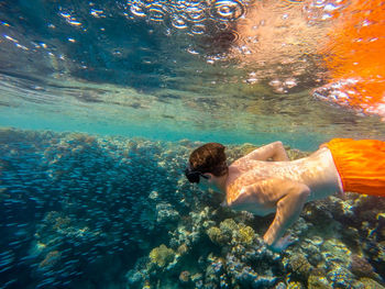 High angle view of shirtless teenage boy snorkeling in sea