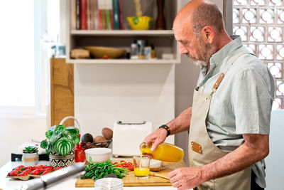 Midsection of man standing on table at home