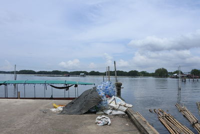 Man sitting on riverbank against sky