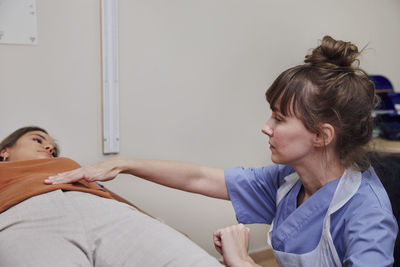 Doctor examining patient's stomach during appointment