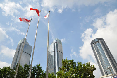 Low angle view of singaporean flags against modern buildings in city
