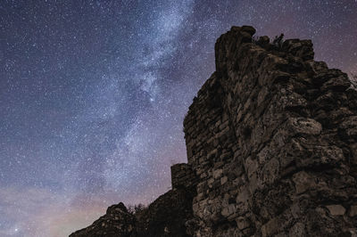 Low angle view of rock formation against sky at night