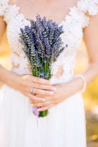 Midsection of woman holding flower bouquet