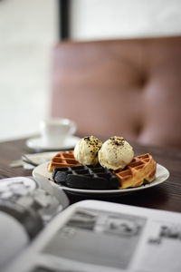 Close-up of waffles with ice cream on table