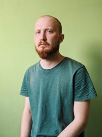 Portrait of young man standing against gray background