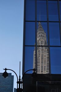 Low angle view of modern building against blue sky