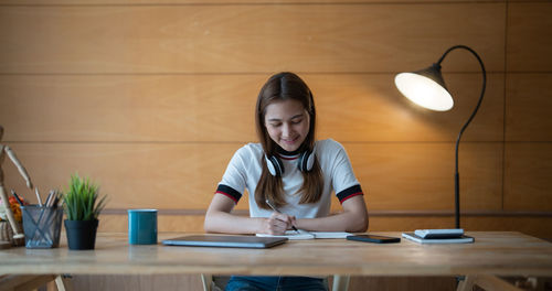 Portrait of young woman using laptop on table