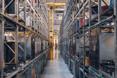 Interior of modern storage warehouse with coils of colored cable on metal shelves. 