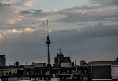 Buildings in city against cloudy sky