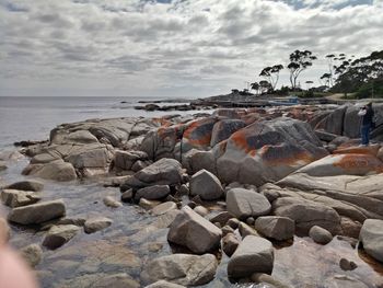 Rocks on beach against sky