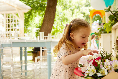 Cute girl touching flowers outdoors