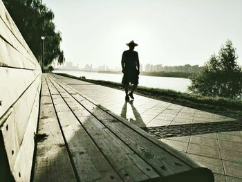 Rear view of woman walking on footbridge