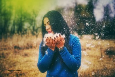 Close-up of woman standing against tree during winter