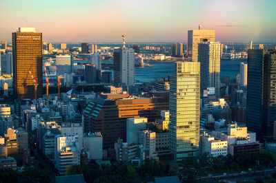 High angle view of modern buildings against sky in city during sunset