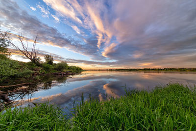 Scenic view of  river against sky during sunset