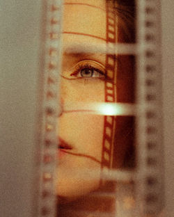 Close-up of woman looking through glass window