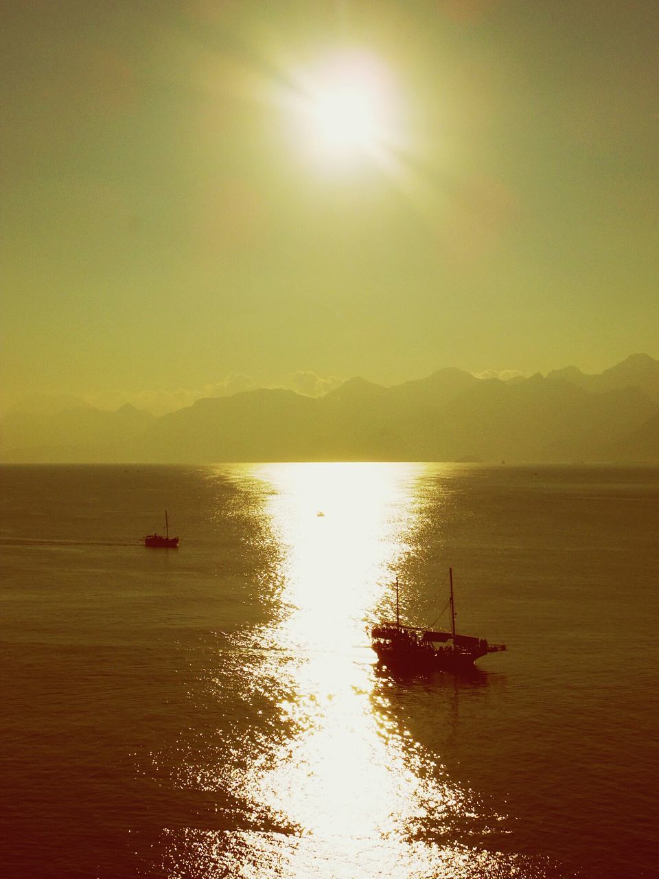 water, nautical vessel, sun, transportation, sea, boat, sunset, tranquil scene, mode of transport, tranquility, scenics, beauty in nature, waterfront, horizon over water, sky, reflection, nature, silhouette, sunlight, idyllic