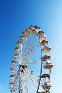 Low angle view of ferris wheel against blue sky