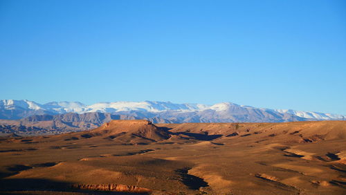 Scenic view of desert against clear blue sky