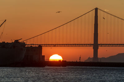 View of suspension bridge against sky during sunset