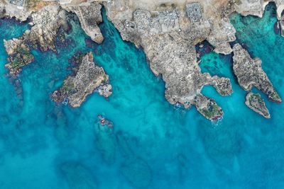 High angle view of blue sea and rocks