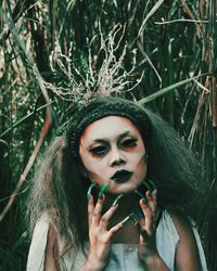 Close-up portrait of young woman in halloween costume standing at forest