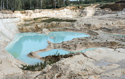 Quarry with kaolin clay, light sand and blue water,  landscape, industrial excavation of minerals 