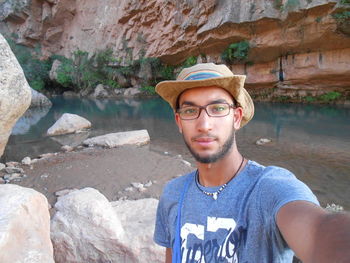 Portrait of young man standing on rock