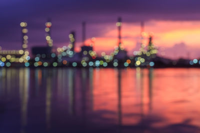 Defocused image of illuminated lights in river at night