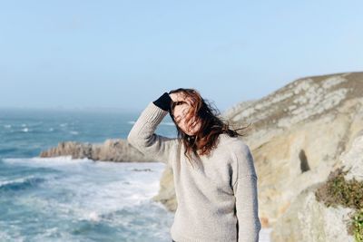 Woman standing at beach against clear sky