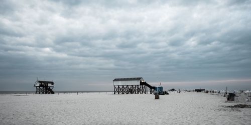 Lifeguard huts on beach against sky