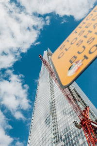 Low angle view of modern building against cloudy sky