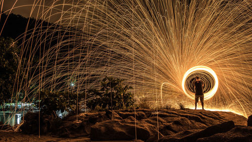Rear view of man standing against wire wool