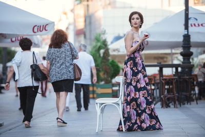 Rear view of women walking on street in city
