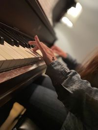 Cropped hand of man playing piano