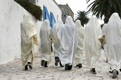 Rear view of people walking on footpath