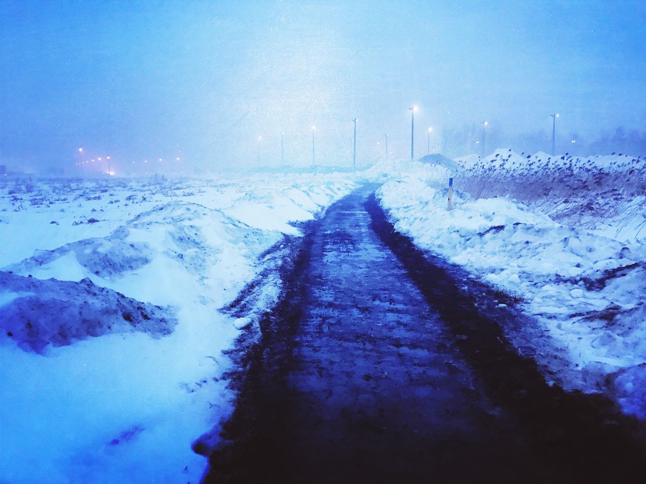 snow, winter, cold temperature, road, nature, the way forward, transportation, direction, no people, covering, environment, street, sky, scenics - nature, tranquil scene, tranquility, beauty in nature, illuminated, white color, diminishing perspective, outdoors, snowcapped mountain