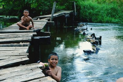 Portrait of smiling boy sitting on lake