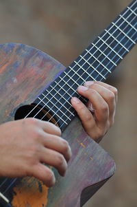 Cropped hand of man playing guitar