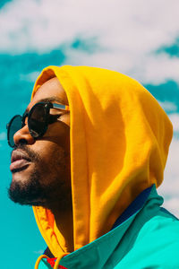 Close-up of man looking away against sky