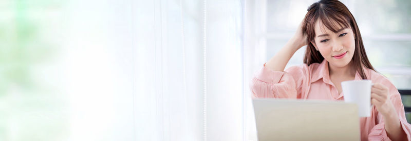 Young woman looking away while using mobile phone