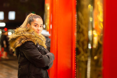 Young woman looking away while standing in winter